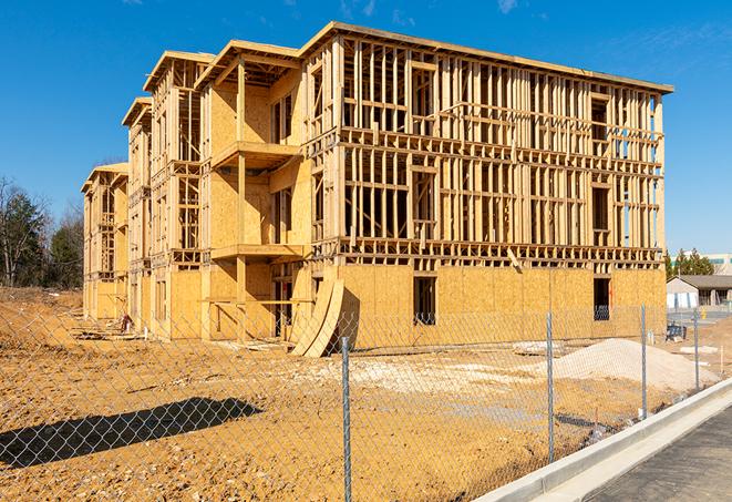 a temporary chain link fence winding around a construction site, outlining the project's progress in Tipton IA